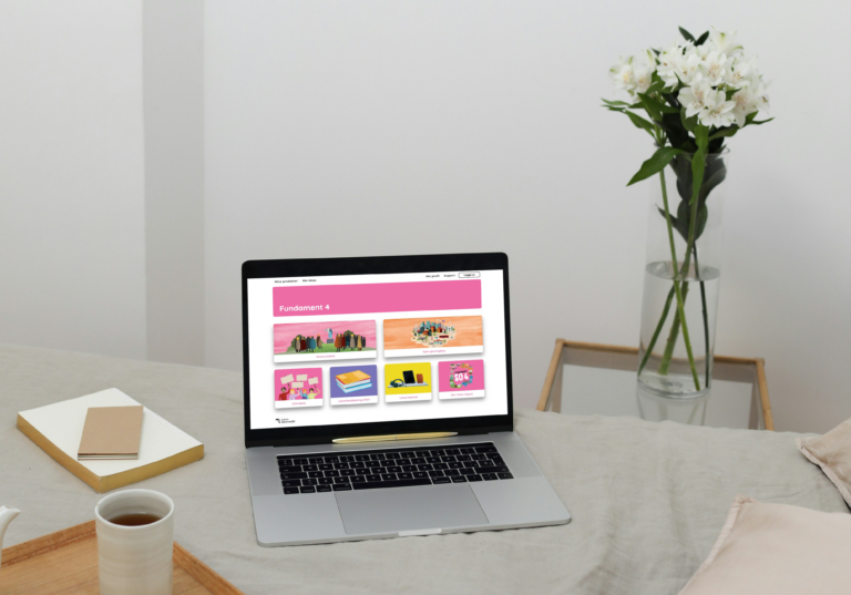A laptop on a sleek desk displaying Tukan Digital's new EdTech platform and digital learning materials.