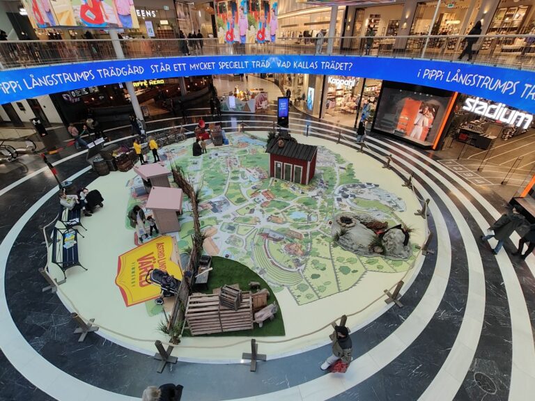 Astrid Lindgren's World - Digital Out-of-Home (DOOH) advertising and exhibition technology at Mall of Scandinavia for Astrid Lindgren's World. A custom-designed solution featuring an interactive floor installation and suspended screens. 