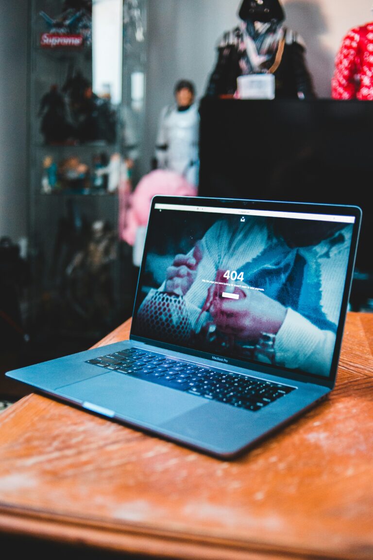 A blue laptop on a wooden table in an office